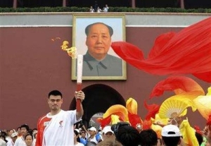 Houston Rockets star, Yao Ming carries the Olympic Torch under Mao Zedong's portrait in Beijing.